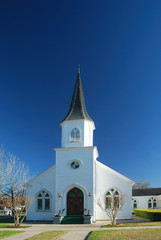 Community church is pristine white against a dark blue sky.
