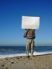 man with blank billboard in the beach