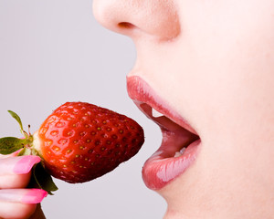 Mund von Mädchen beisst in Erdbeere