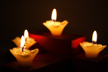 four candles are lighting at the dark.