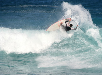 Young surfer flips out of a big wave