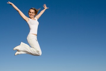 happy fit healthy woman jumping for joy