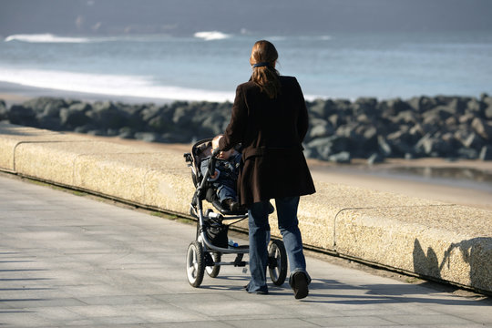 femme qui se promene avec son enfant dans une poussette