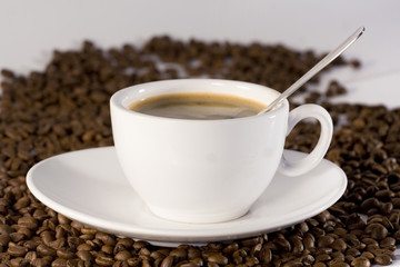 Cup of coffee view from above and coffee beans background
