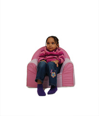 petite fille assise sagement sur un fauteuil