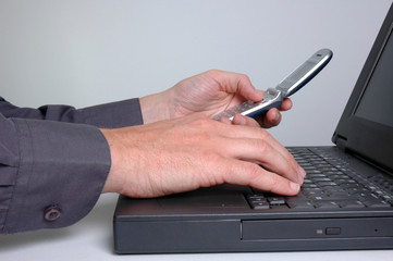 Businessman using a laptop and mobile phone.