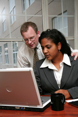 Businesswoman working on a computer in an office with coworker