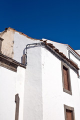 Fototapeta na wymiar old spanish white house under clear and blue sky