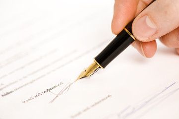 Fototapeta premium someone signing a document with a pen. text is blur. 