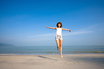 woman jumping and having fun by the beach