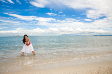 Fototapeta na wymiar woman having fun splashing in the sea by the beach