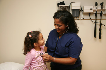 Hispanic nurse checks white child