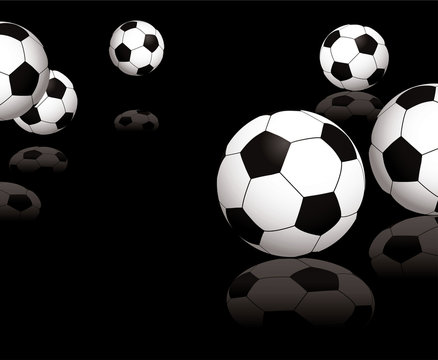 Collection of footballs on a black reflective background