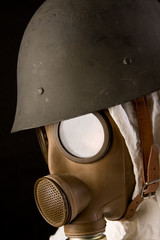 Fototapeta premium Military person in gas mask and helmet on black background