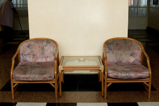 Shot of hotel interior with two chair and rusty wall