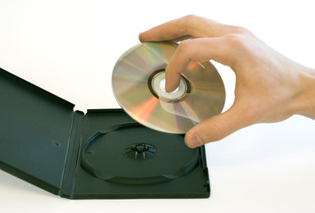 Man's hand holding a compact disc taken from a box