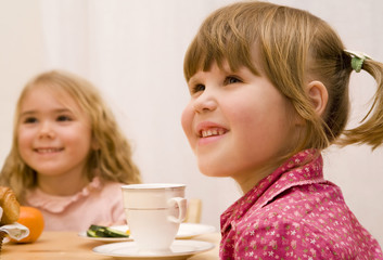 Two little girls have a breakfast  