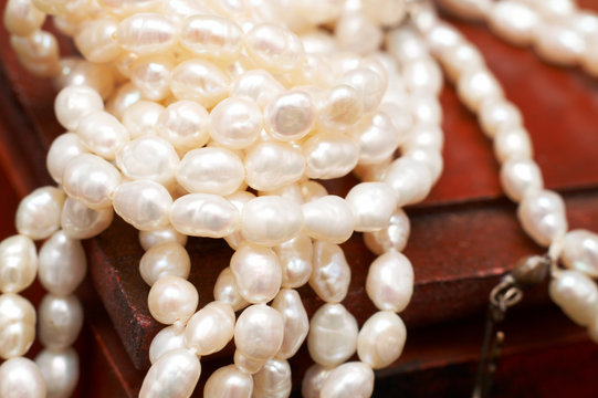 String of white real river pearls on brown wooden box