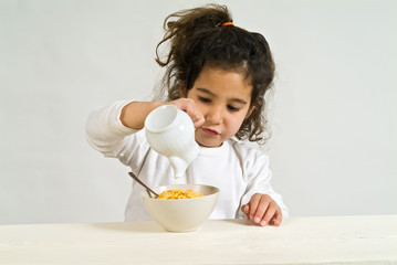 little girl holding a spoon with cereals
