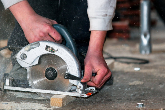 Ouvrier d&eacute;coupant planche de bois avec tuiles