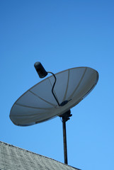 Black satellite dish against a blue sky
