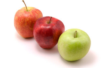 green and two red apples, isolated