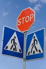 Road sign with stop and crosswalk pedestrian symbols warning