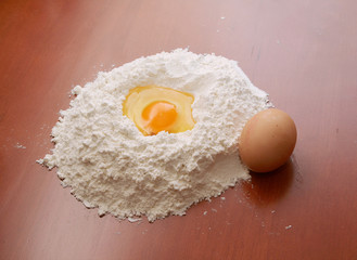 Flour and eggs on wooden table
