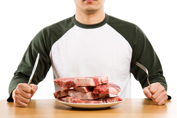 A man holding a knife and a fork with a stack of raw steak