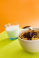 Corn flakes on the vase with jam and spoon