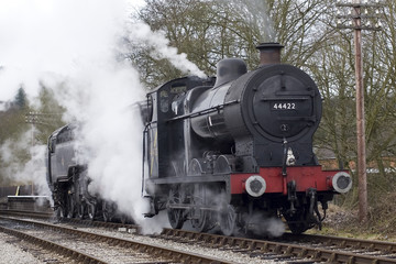 A steam engine pulls into a railway station