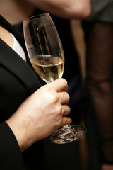 The woman holds a glass with wine in a hand