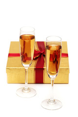 Glasses of champagne and gift on white