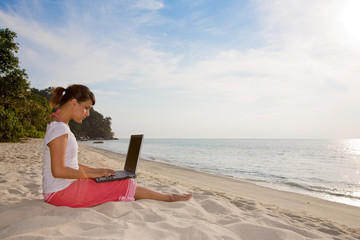 woman relaxing and working by the beach