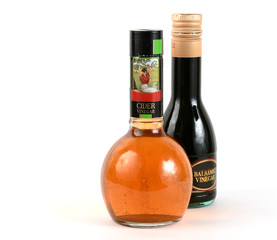 Bottles of cider  and balsamic vinegar, on white background
