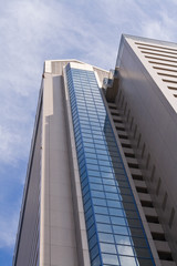 Image of a high skyscraper and a cloudy sky.
