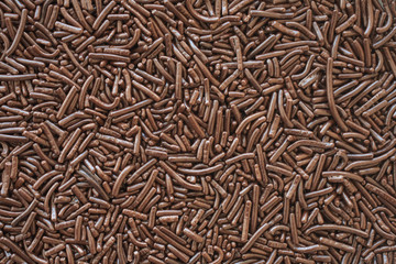 A bed of brown chocolate sprinkles used for cake decoration 