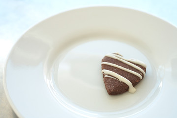 The last heart shaped cookie on a white ceramic plate