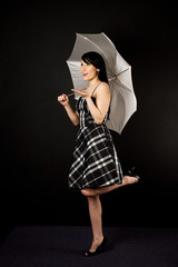 A fashion shot of a beautiful woman posing with an umbrella
