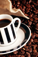 some coffee beans and a jute sack with a cup