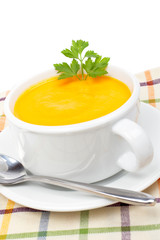 Carrots puree on white cup over squared mat. Shallow DOF