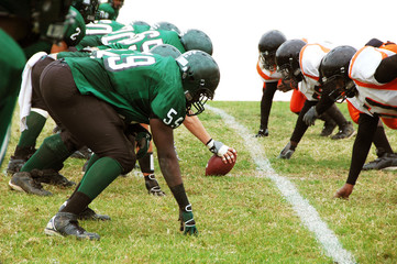 Football players ready to snap the ball isolated