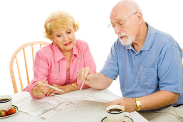 Senior couple filling out their absentee ballots at home.  