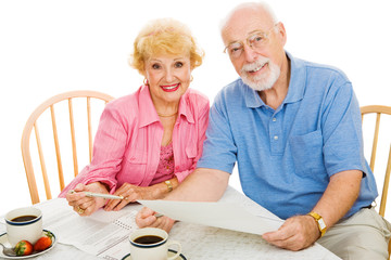 Senior couple using absentee ballots to vote in an election.