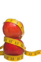 Two red apples wrapped in a tailor's measuring tape.