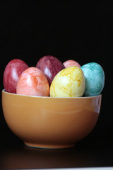 uova colorate in ciotola arancione con sfondo nero 5