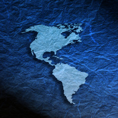 Outline map of American Continent on blue textured paper © Jane