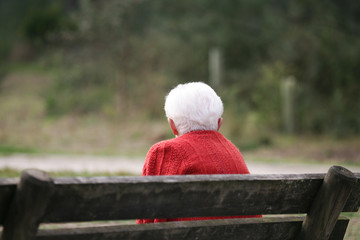 vieille dame avec les cheveux blancs assise sur un banc