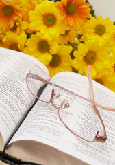 Open Bible with glasses and spring flowers 