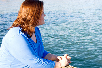 Beautiful plus sized model relaxing by the ocean.